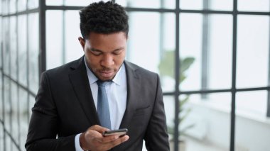 Çekici Afrikalı Amerikalı genç adam telefon kullanıyor.
