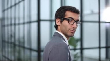 Adliye sarayının yakınında bir takım elbisenin içinde duruyor..