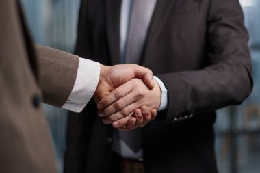 employees greeting each other with a handshake in the office corridor .