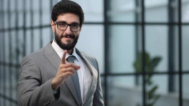 Ofiste kendinden emin bir şekilde duran genç işadamı.