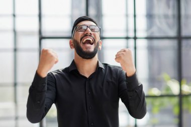 Stadyumdaki iş adamı, havayı yumrukluyor, alçaktan bakıyor.