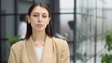 Genç kız ofisteki kameraya gülümsüyor.