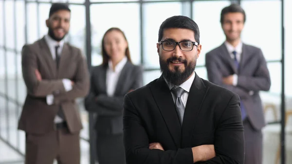 positive employee posing for company business catalogue with colleagues at background, having photo shoot in office