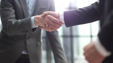 Ofis toplantısında iki farklı profesyonel iş adamı yönetici lider el sıkışıyor.