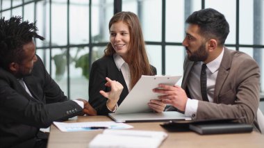 Ofiste birlikte çalışırken kendine güvenen üç iş adamı.
