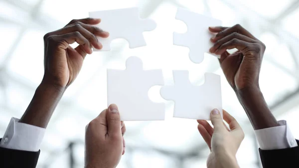 Business teamwork with white puzzle of four pieces cooperation unity concept