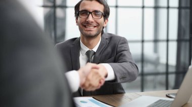 Ofisteki bir toplantıda iş ortaklarının el sıkışması.
