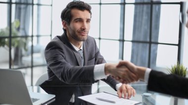 Menajer, müşteriyi el sıkışarak karşılıyor..