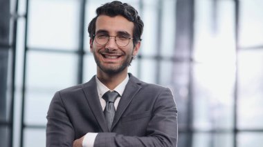 Karşılıklı kolları olan yakışıklı bir iş adamı.
