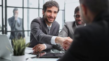 Anlaşmayı mühürlüyorum. En iyi üç adam masada oturuyor ve el sıkışıyor.