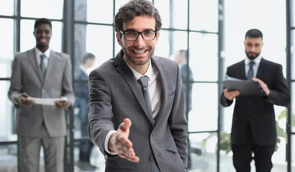 現代的なオフィスで拡張手で立って 握手を提供する笑顔のビジネスマンの頭のショットの肖像画 — ストック写真