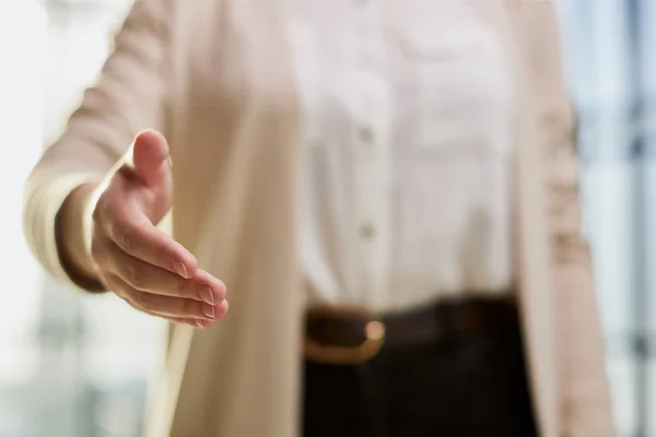 stock image businesswoman proposes partnership, gives hand at camera for handshake