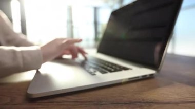 Dizüstü bilgisayar klavyesinde yazı yazan ve ofis masasında internette sörf yapan kadınların görüntülerini kapat