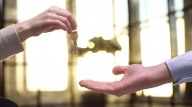 Elden ele. Ev sahibi kadın satıcının yakın plan fotoğrafı. Anahtarları elinde tutuyor. Başarılı bir anlaşma ve peşinat alındıktan sonra genç kadın kiracıya veriyor.