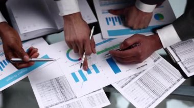 Yakın plan. İş arkadaşları masadaki grafiğe yukarıdan bakın.