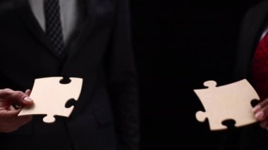 Birleşen iki beyaz Puzzle parçaları siyah arka plan üzerine yakın çekim iş ortakları