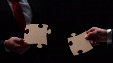 Birleşen iki beyaz Puzzle parçaları siyah arka plan üzerine yakın çekim iş ortakları