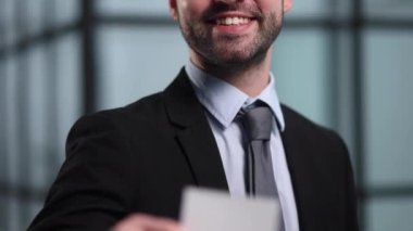 Boş beyaz kartvizit modern ofis binası içinde holding iş adamı. Ücretsiz boş kopya alanı.
