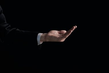 Bir erkeğin eli siyah arka planda izole edilmiş bir şey için yalvarır. Avuç içi yukarı, yakın..