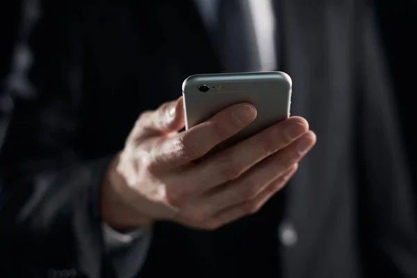 Geschäftsmann Blickt Auf Smartphone Bildschirm Der Hand Auf Dunklem Hintergrund — Stockfoto