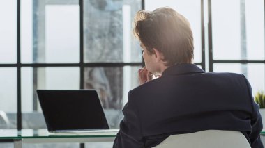 Portre işadamı işyerinde masa başında oturuyor.,