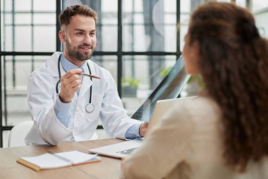 Doktor muayenehanesinde röntgene bakan yetenekli genç bir erkek doktor.