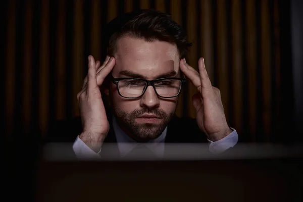 Worried businessman holding his head in his hands