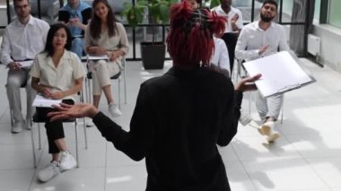Çok ırklı iş adamlarının iş konferansında ya da seminerde ayakta durup seyircilere gülümsemelerini alkışlayan yan görüşü