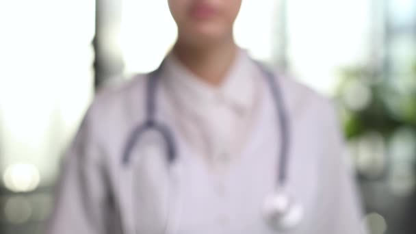 薬理療法 ポートレートを閉じる新しい効果的な薬薬を提示するカメラを見て女性医師の薬剤師 女性医療従事者の手で黄色のカプセルに焦点を当てる — ストック動画