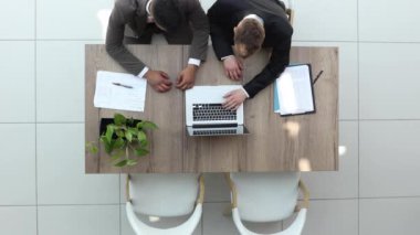 Two happy businessmen working together on a laptop