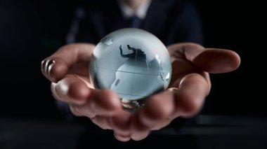 Dünya küresini mavi renkte tutan ellerin yakın çekimi