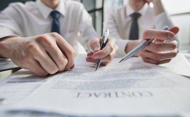 Erkek ellerinin belgenin üzerinde kalemle yakın plan görüntüsü