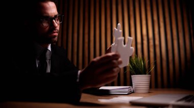 Çekici genç adam ofisteki masada bir sorunu çözüyor.