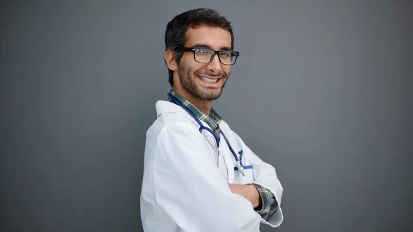 Portrait Positive Male Doctor Posing Crossed Arms Smiling Camera Grey — Stock Photo, Image