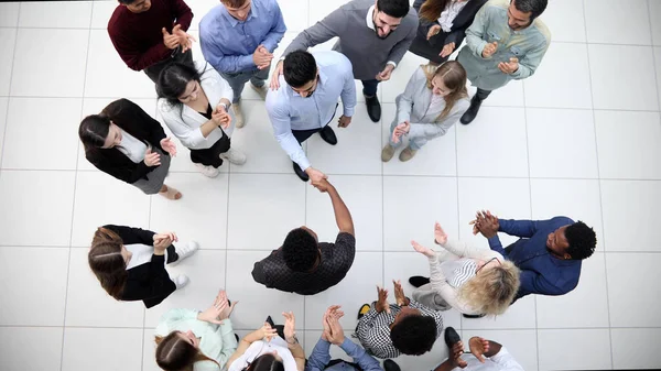 Ofis çalışanları ve yabancı çalışanlar ofis lobisinde durup konuşuyorlar..