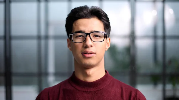 年轻英俊的亚洲男子戴着眼镜 摆出一副拍照的姿势 微笑着走近镜头 — 图库照片