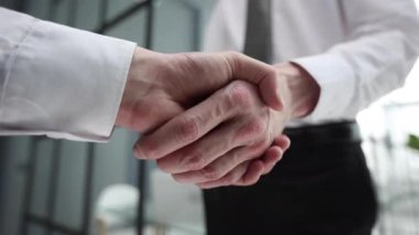 Toplantı salonunda iş ortakları el sıkışıyor.