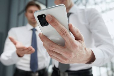 Akıllı telefonu kullanan, parmak basan, sosyal medya interneti okuyan, metin yazan ya da internetten alışveriş yapan bir adam. Cep telefonu evde ya da işte.