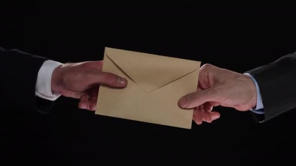 商人一边握手 一边用黑色的背景给对方一个普通的信封 — 图库视频影像