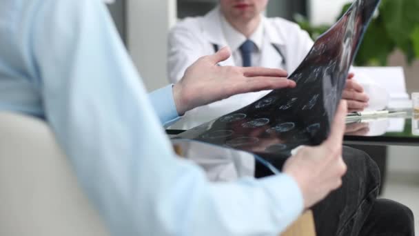 Patienten Sitter Vid Bordet Och Visar Röntgenbilden För Läkaren Receptionen — Stockvideo