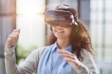 Sanal gerçeklikte nesnelere dokunmaya çalışan kız.