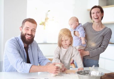 Young family with daughter and son in the kitchen