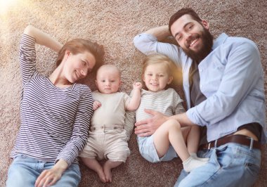 happy family mother father and kids at home. laying