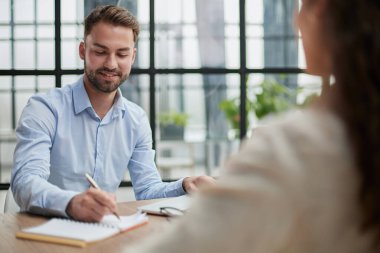 Modern bir ofiste sakallı yakışıklı bir adam.