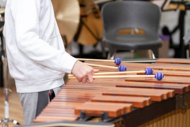 Musician hands with four drumsticks playing a marimba