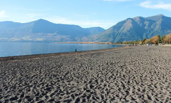 Şili, Pucon 'da volkanik kumla kaplı bir gölün kumsalı.
