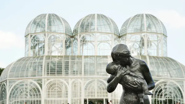 Yazar Joo Zaco Paran 'ın eserinin kopyası olan çeşme, arka planda Brezilya' nın Curitiba Botanik Bahçesi 'ndeki tropik bitki serası.