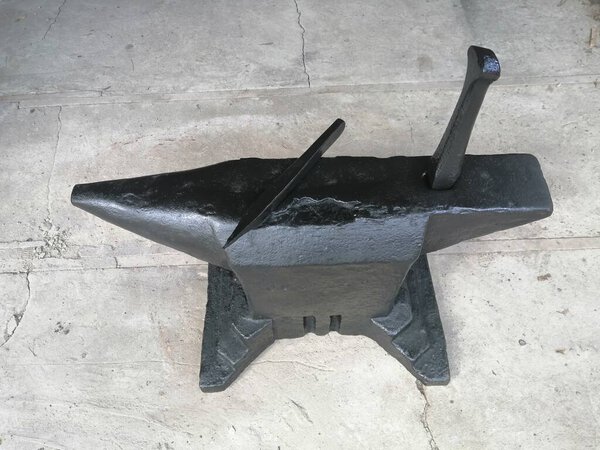 Old blacksmith forged anvil with tool 