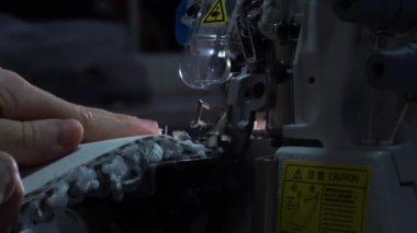 Dikiş makinesinin iğnesinin yavaş çekimde yakın çekimi. Dikiş atölyesinde terzi gri kumaş dikiyor. Kumaşı dikme süreci. Yüksek kalite 4K görüntü