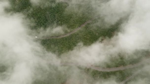 Vol cinématographique au-dessus de la route dans les nuages. Les voitures roulent le long de la route Images FullHD de haute qualité